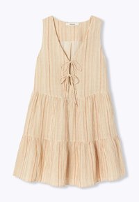 Robe légère sans manches avec un décolleté en V profond. Présente des rayures verticales en pêche et crème, un devant à nouer et une jupe à volants.