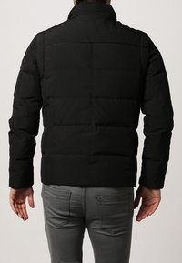 Czarna puchowa kurtka z wysokim kołnierzem, pikowaną fakturą i elastycznymi mankietami. Charakteryzuje się prostym krojem i gładką powierzchnią.