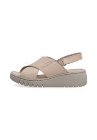 Beige leren sandalen met kruislingse banden, verstelbare hielband en een gestructureerde grijze platformzool met een geribbelde patroon.