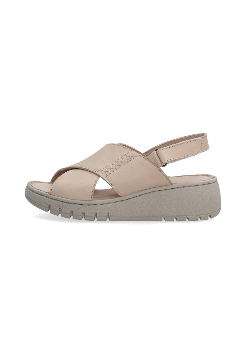 Beige leren sandalen met kruislingse banden, verstelbare hielband en een gestructureerde grijze platformzool met een geribbelde patroon.