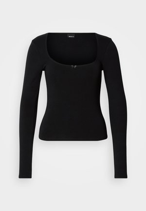 Črna oprijeta dolga majica z dolgimi rokavi, kvadratnim izrezom in majhnim dekorativnim lokom na sredini sprednje strani.