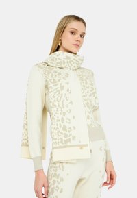 Maglione color crema con un motivo a stampa leopardata testurizzato in beige chiaro. Presenta un colletto alto, maniche ampie e dettagli a coste.