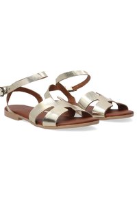 Metallische gouden sandalen met meerdere banden, een platte zool en een bruine leren binnenzool. Voorzien van een verstelbare enkelband voor een goede pasvorm.