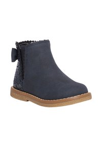 Botines de ante azul marino con borde ondulado, suela de goma y un acento decorativo de estampado animal en la parte posterior con un detalle de lazo.