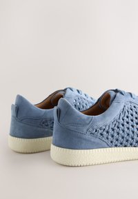 Scarpe in suede azzurro chiaro con un design intrecciato e suola in gomma color crema. Presentano dettagli ad anello e una silhouette a taglio basso.