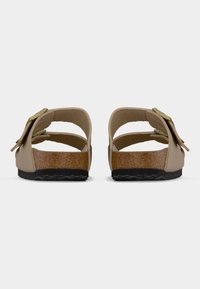 Ταμπά σανδάλια slide με ανοιχτή φτέρνα, με μεσαία σόλα από φελλό και εξωτερική σόλα από μαύρο καουτσούκ. Χρυσές λεπτομέρειες διακοσμούν το λουράκι.