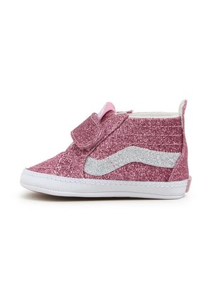 Różowy dziecięcy błyszczący sneaker z białym falowanym paskiem, zapięciem na rzep i białą podeszwą, widoczny z boku na białym tle.