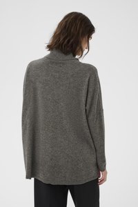 Übergroßer grauer Pullover mit hohem Kragen, lockerer Passform und geripptem Saum. Weiche Textur, minimale Nähdetails und überschnittene Schulternähte.