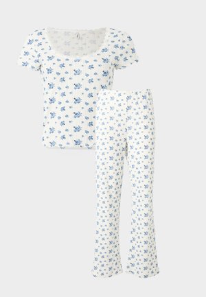 Set format din top alb cu mâneci scurte, cu dungi și pantaloni asortați, decorat cu un mic imprimeu floral albastru și decolteu în formă de val la top.