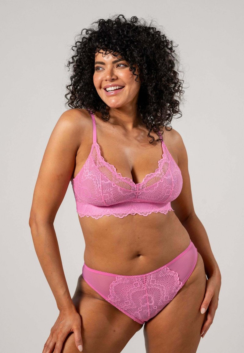 Ljusrosa spets-bra med scallopade kanter och justerbara band, tillsammans med matchande trosor med spetskant, som har genomskinliga paneler.