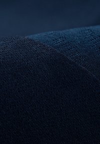 Donkerblauwe getextureerde stof met een geweven patroon, bestaande uit fijne draden en een lichte glans. Het materiaal lijkt stevig en strak gebreid te zijn.