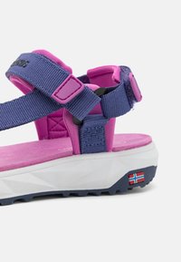 Fialové a růžové venkovní sandály s nastavitelnými popruhy a silnou bílou podrážkou, na patě s malou norskou vlajkou.