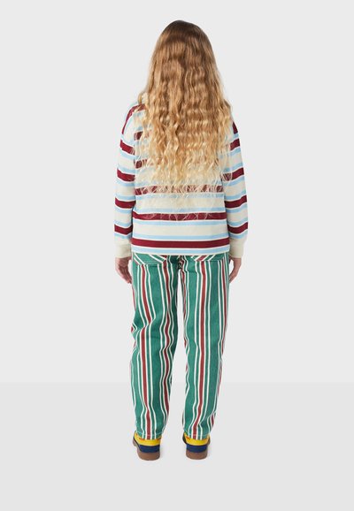 Gestreept overhemd met lange mouwen in blauw en bordeaux, gecombineerd met groene corduroy broek met verticale strepen in rood en wit.