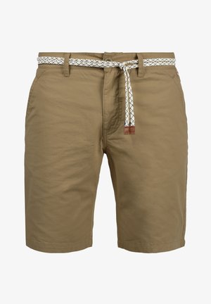 Khakinväriset polvenmittaiset shortsit, joissa etutaskut ja valkoinen kudottu vyö, jonka nahkaiset päät on solmittu vyötärölle.