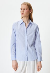 Himmelblau- und weiß gestreifte Button-down-Bluse mit langen Ärmeln, Kragen und silbernen Knöpfen. Der Stoff wirkt glatt und leicht glänzend.