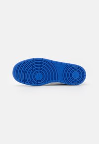 Blue rubber sole with patterned tread and a central circular design; features grooves and indentations for traction.