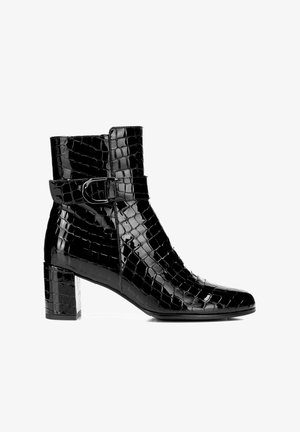 Stivale alla caviglia in pelle verniciata nera con texture in coccodrillo, punta quadrata, cinturino con fibbia e tacco a blocco spesso. Superficie liscia con finitura lucida.