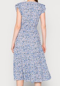 Blaues Blumenkleid mit einem gestuften Design, kurzen Ärmeln und einer taillierten Passform mit einem kleinen Rüschendetail, aus leichtem Stoff gefertigt.