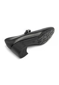 Chaussure en cuir noir à petit talon avec un bout arrondi, une sangle réglable et une semelle extérieure en caoutchouc texturé dotée de motifs antidérapants.