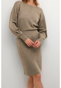 Abito lavorato a maglia beige, con scollo tondo, maniche lunghe a palloncino, vita aderente e silhouette fino al ginocchio. Texture morbida, design minimale.