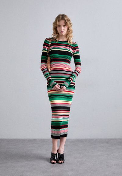 Abito a righe con coste, caratterizzato da maniche lunghe e un motivo multicolore nei toni del verde, rosso, nero e giallo; lunghezza fino al polpaccio con design aderente.