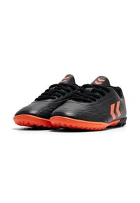 Scarpe da calcio nere con suola arancione e dettagli in arancione, caratterizzate da una superficie testurizzata e un sistema di allacciatura. Logo ben visibile sui lati. Design leggero.
