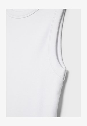 Primo piano di un top bianco senza maniche a coste che mostra i dettagli delle cuciture del collo e delle asole per le braccia.