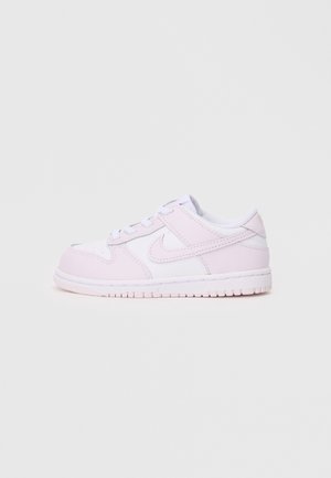 Sneaker basse in pelle bianca e rosa pallido con il logo Nike, chiusura con lacci e suola scanalata su sfondo bianco.