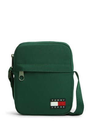 Petit sac bandoulière carré vert foncé avec poche avant zippée et écusson logo Tommy Jeans en bas à droite.