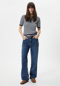 Mørkeblå og hvidstribet strik polo skjorte med krave, parret med højtaljede blå jeans af denim og brune lædersko.