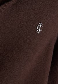 Maglione lavorato a maglia marrone con un piccolo logo argento, dal tocco morbido e una vestibilità leggermente ampia.