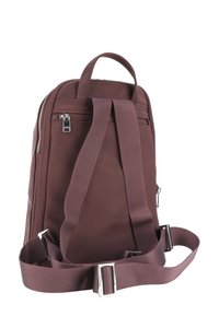 Burgundský batoh vyrobený z odolného materiálu, s hlavním oddílem na zip, nastavovacími popruhy a rukojetí pro snadné nošení.