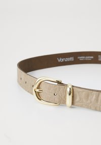 Light beige coated leather belt with a textured surface and gold metal buckle. Features multiple holes for size adjustment.