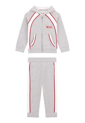 Ensemble de sport gris comprenant un sweat à capuche zippé avec des accents rouges et blancs, des poches kangourou, et un pantalon de jogging assorti avec des rayures sur les côtés.