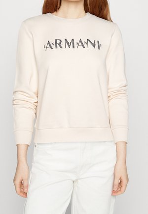 Sudadera beige claro de manga larga, con puños y dobladillo acanalados. Presenta el nombre de la marca "Armani" en una elegante fuente de patchwork en el pecho.