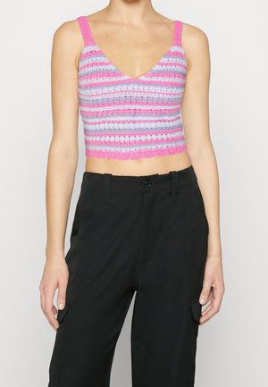 Lyserød og lavendel stribet cropped top med strikket tekstur og bølget bund; har brede stropper og V-hals design. Sorte bukser bæres nedenunder.