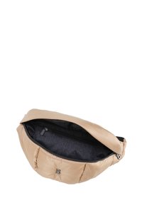 Borsa puffa beige dalla forma arrotondata, con chiusura a zip. L'interno presenta un rivestimento scuro con un branding ripetuto. Decorata con un logo.