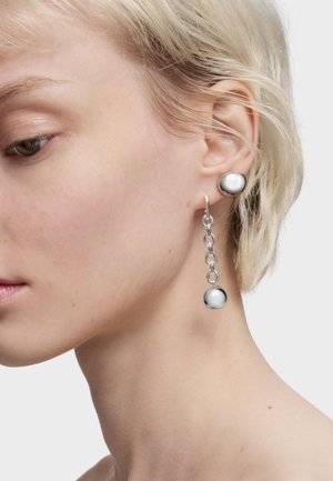 Pendientes de plata con un botón redondo y una cadena colgante con una esfera, que presentan un acabado metálico elegante y una textura suave.