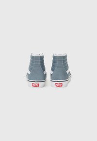Hoge sneakers van blauwe suede met witte accenten. Beschikt over een gevoerde kraag, rubberen zool en een rood logo op de hak.