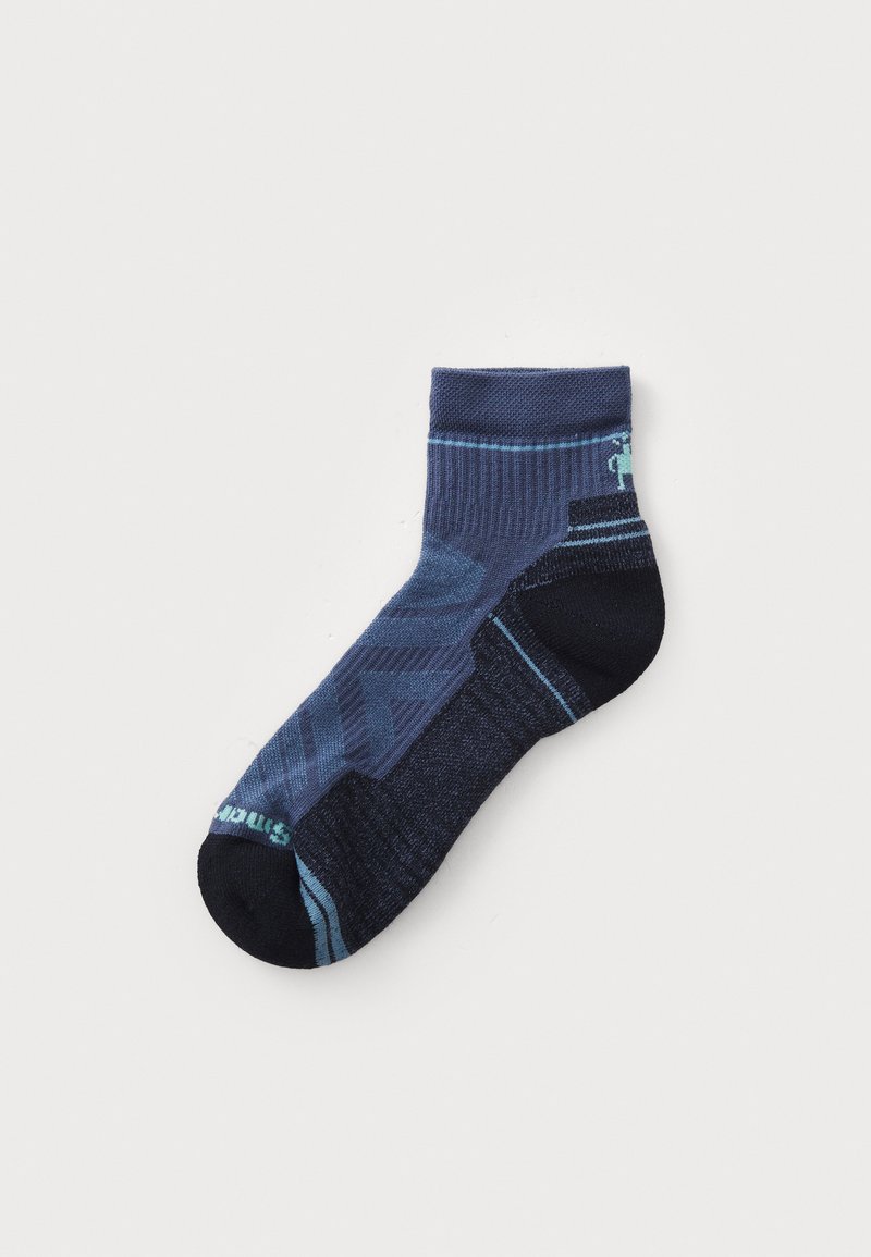 Calcetín de tobillo azul marino con un patrón texturizado, que presenta tonos variados de azul y una puntera negra. Incluye un sutil distintivo en el lateral.