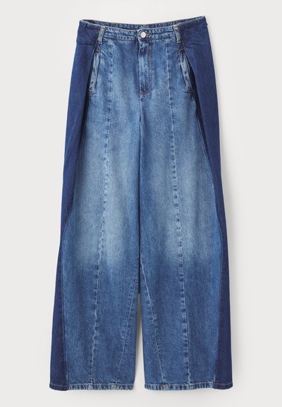 Denim leveled leggin, joka sisältää kaksivärisen muotoilun vaaleansinisen ja tummansinisen sävyn, etupleikkeet ja nappisuljenta vyötäröllä.