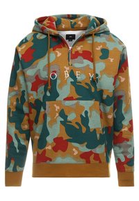 Maskovací mikina v zelených, červených a béžových odstínech, s přední kapsou, krkem na půl zip a bílým potiskem "OBEY". Měkká textilie.