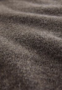 Pruun tekstuuriga kangas, mis on pehme ja karvane ning millel on õrnad varjundimuutused, mida iseloomustavad õrnad voldid ja soe, kutsuv toon.