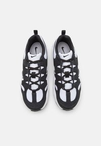 Sneakers Nike w czarno-białym wzorze, z siateczkowych i zamszowych materiałów, o fakturowanej powierzchni oraz z wyraźnym logo na języku.