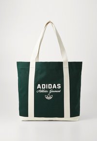 Dunkelgrüne Adidas Tragetasche mit weißen vertikalen Riemen und "Athletic Garment"-Text sowie Logo auf der Vorderseite.