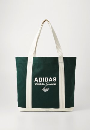 Mørkegrønn Adidas tote-bag med kremfargede håndtak og bunn, med teksten "Athletic Garment" og Adidas trefoil-logo på forsiden.