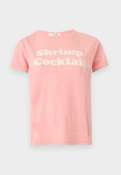 Ροζ κοντομάνικη μπλούζα με λευκό κείμενο «Shrimp Cocktail» στο στήθος, εμφανιζόμενη σε απλό ανοιχτό γκρι φόντο.
