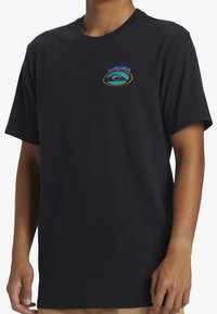 Camiseta de algodón negra con un colorido logotipo de Quiksilver en el pecho izquierdo. Cuello redondo clásico y mangas cortas. Textura suave.