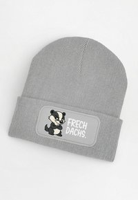 Gray knitted beanie with a ribbed texture. Features a patch with a cartoon badger and the text “FRECH DACHS.”