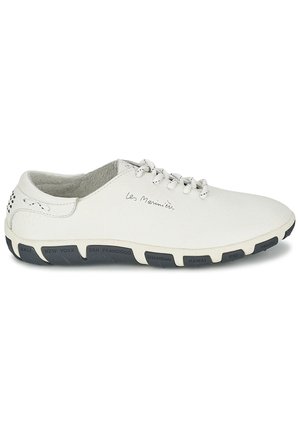 Chaussure en cuir blanc avec un design à lacets et semelle en caoutchouc grise comportant des noms de villes. Texture lisse avec de légères perforations sur les côtés.